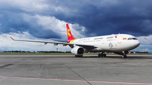 Airplane on runway against sky