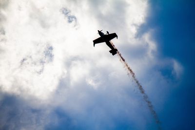 Low angle view of airplane flying against sky