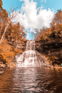 Scenic view of waterfall against sky during autumn