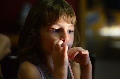 Close-up of girl having drink while sitting at home