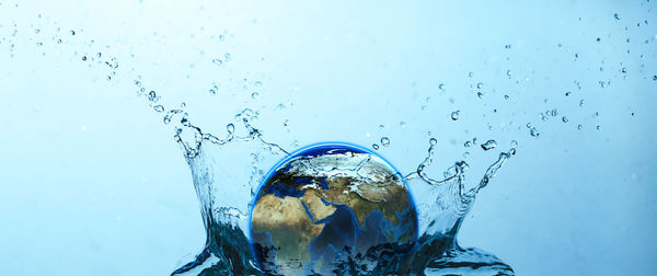 Close-up of water splashing against blue sky