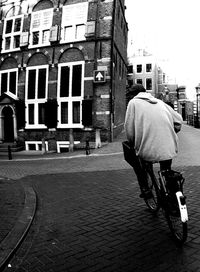 Rear view of woman riding bicycle on road