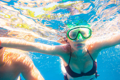 Close-up portrait of young woman swimming in pool