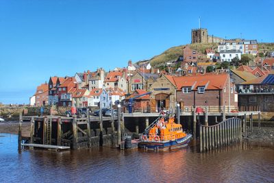 Boats in river with buildings in background