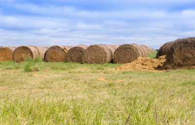 Hay bales on field against sky