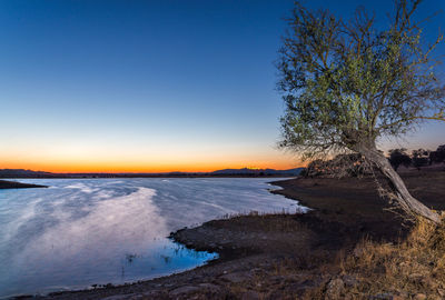 Scenic view of sea against clear sky at sunset