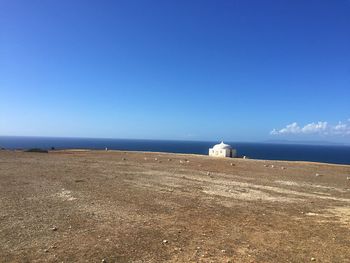 Scenic view of beach against clear blue sky