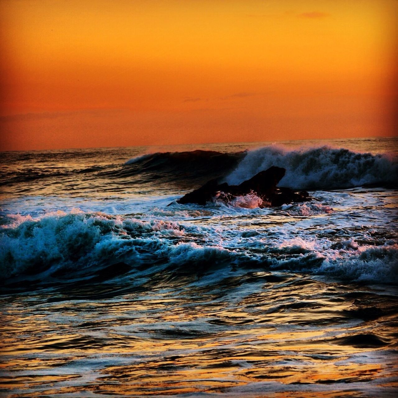 water, sunset, sea, scenics, orange color, beauty in nature, wave, tranquil scene, waterfront, nature, tranquility, idyllic, horizon over water, sky, motion, surf, remote, dusk, rock - object, non-urban scene