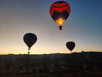 Hot air balloons flying against sky during sunset