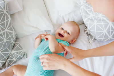 Cropped hands of mother touching baby