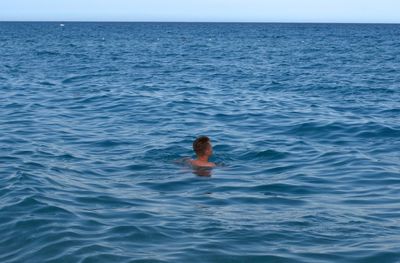 A teenager swims in the mediterranean sea