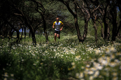 Full length of man amidst trees in forest