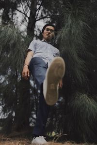 Low angle view of young man in forest