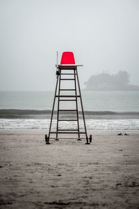 Lighthouse at beach against clear sky
