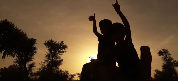 Low angle view of silhouette statue against sky during sunset