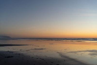 Scenic view of beach against sky during sunset