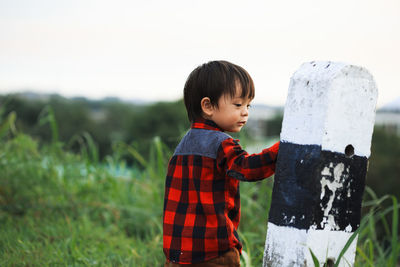 Side view of boy standing outdoors