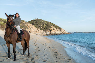 Horse riding horses on beach