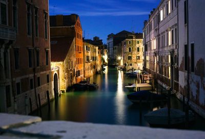 Boats in canal along buildings