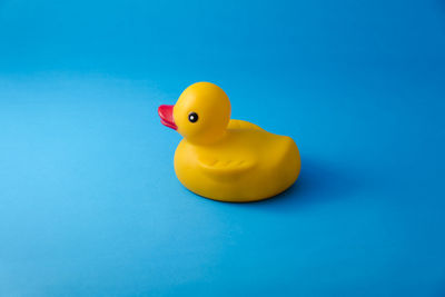 Close-up of yellow toy over blue background