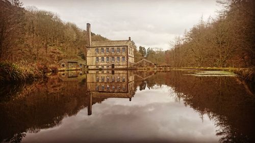 Reflection of building in lake against sky