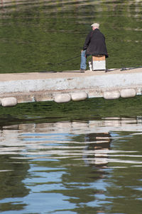 Rear view of man fishing at lake