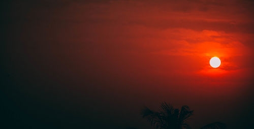 Silhouette tree against orange sky