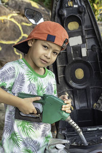 Portrait of boy filling motorcycle