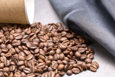 Coffee beans next to a cardboard glass. food and drink concept