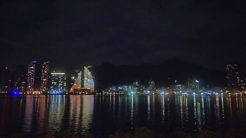 Low angle view of illuminated cityscape against sky at night