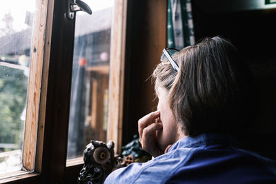 Portrait of woman with reflection on window