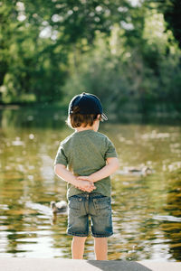 Rear view of boy standing in lake