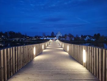 Illuminated bridge against sky at dusk