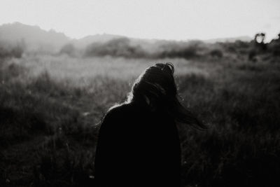 Woman standing on field against sky