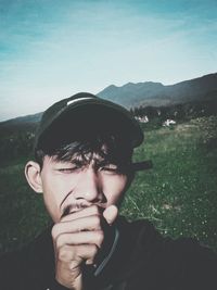 Portrait of young man on land against sky