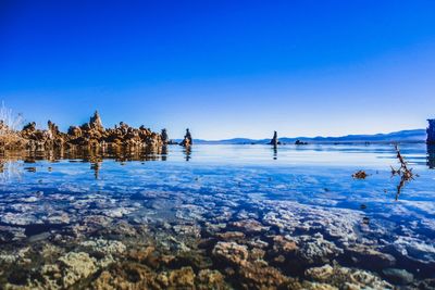 Scenic view of frozen lake against clear blue sky