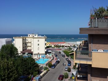 High angle view of city by sea against clear sky