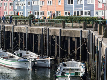 Boats moored on river against buildings in city