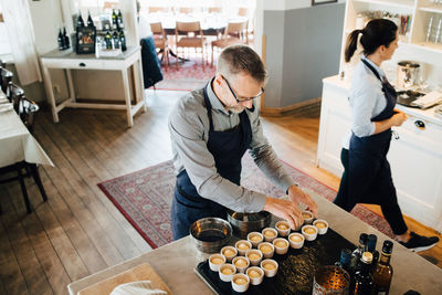 High angle view of owner arranging food on table