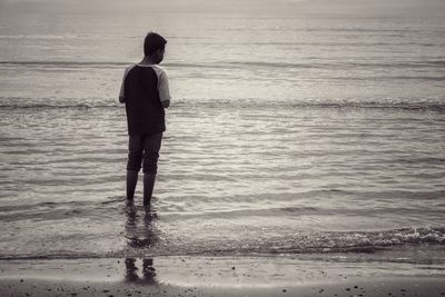 Rear view of man standing on beach