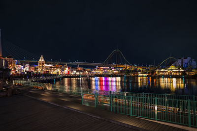 Illuminated bridge over river at night