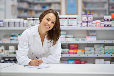 Portrait of pharmacist standing in store