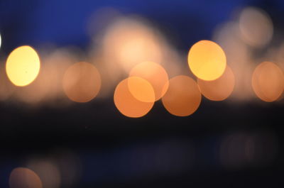 Defocused lights against sky at night