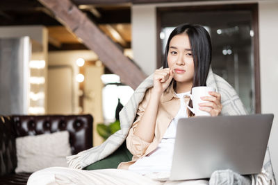 Young woman using laptop at home