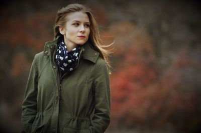 Beautiful woman looking away while standing with hands in pocket