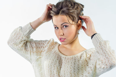Portrait of young woman wearing hat against white background