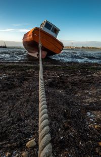 Wooden post on beach against sky