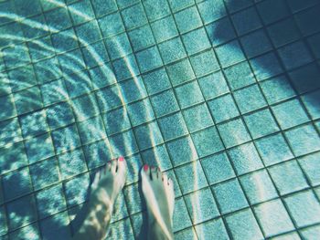 Low section of people walking on tiled floor