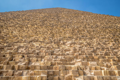 Low angle view of stone wall against sky