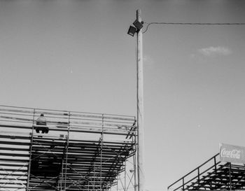 Low angle view of man sitting on bleachers against sky